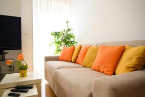 阿斯科利皮切诺L'Attichetto的客厅配有带橙色和黄色枕头的沙发