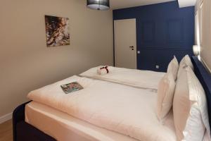 克卢日-纳波卡Ares ApartHotel的蓝色墙壁的客房内配有2张白色的床
