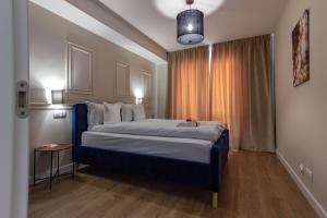 克卢日-纳波卡Ares ApartHotel的一间卧室设有一张大床和一个窗户。