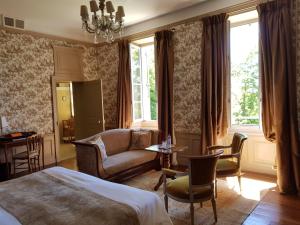 阿尼瑟厄巴龙Château de Lalande - Teritoria - Périgueux的一间卧室配有一张床、一张沙发和一张桌子