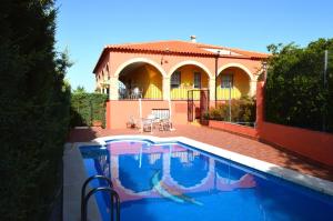 圣克鲁斯德穆德拉Casa Rural ¨La Noria Olaya¨的房屋前有游泳池的房子