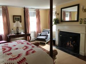 布里奇汉普顿Bridgehampton Inn的一间卧室设有壁炉、一张床和镜子