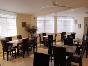 伊察Belle Sand Hotel的用餐室设有桌椅和窗户。