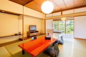 北九州Art Hotel Kokura New Tagawa的客厅配有红色桌子和电视
