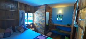 高龙撒冷岛姆派湾邦德旅馆的一间卧室设有蓝色的床和砖墙