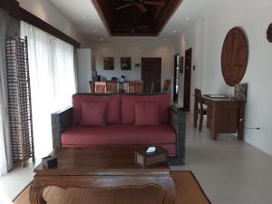 小通奈潘Koh Phangan Pavilions Serviced Apartments的客厅配有红色的沙发和桌子