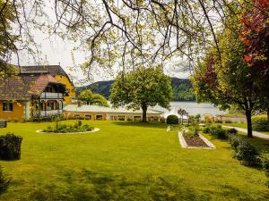 米尔施塔特希别墅酒店的一个大院子,有房子和湖泊
