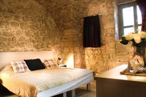 拿撒勒Al-Hakim Boutique Hotel Old Town Nazareth的卧室配有一张石墙床