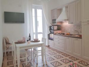卡利亚里CASACRIZIA的厨房配有白色的桌子和桌椅