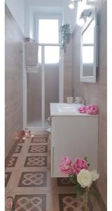 卡利亚里CASACRIZIA的白色的浴室设有水槽和鲜花