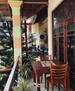 尼甘布蜜蜂巢住宿加早餐旅馆的阳台的天井配有木桌和椅子