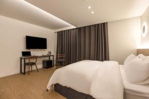 首尔H hotel Gasan的配有一张床和一张书桌的酒店客房