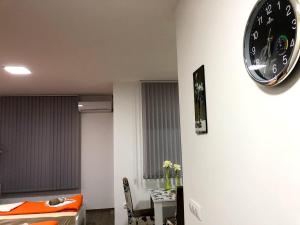 克拉多沃Apartman Bondi的挂在桌子旁边的墙上的钟