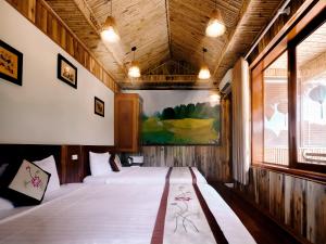 宁平姆瓦洞生态酒店（杭姆瓦）的一间卧室设有两张床,墙上挂着一幅画