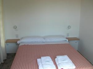 阿肖海Complejo Hueney的一间卧室配有一张床,上面有两条毛巾