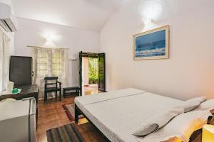 卡兰古特Rodrigues Guest House的一间卧室配有一张床和一台平面电视