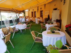 尼特拉欧克酒店的餐厅铺有绿色地毯,配有白色的桌椅