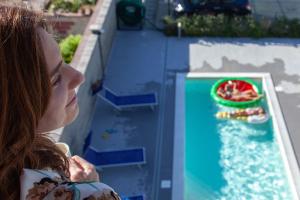 卡普多兰多Terraces d'Orlando - Family Apartments with Sea View and Pool的年轻的女人看着水游戏