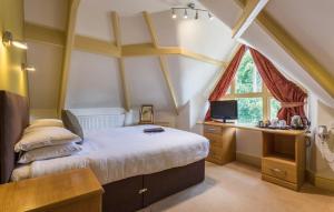 温德米尔Windermere Park inc Free off-site Health Club的一间卧室配有一张床、一张书桌和一个窗户。