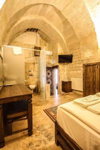 于尔居普天堂洞穴旅馆 - 雷子亚意威的一间卧室配有一张床和一张书桌