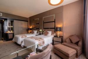 民都鲁新世界套房酒店的酒店客房,配有两张床和椅子