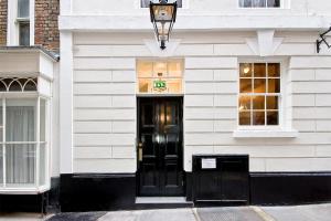 伦敦Eldon Chambers Pod 4 by City Living London的白色的建筑,设有黑色的门和窗户