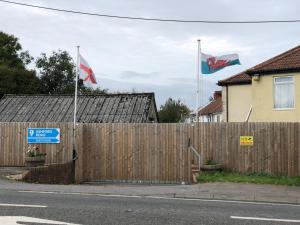 红山1 Ashford Road Guesthouse的木栅栏前悬挂两面旗帜