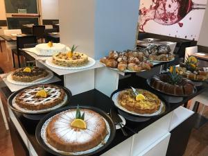 卡萨诺韦米兰马尔彭萨机场创意酒店的柜台上放着一大堆蛋糕和糕点