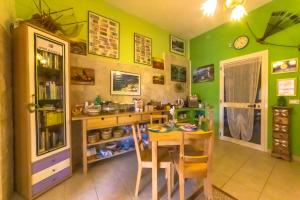 维耶斯泰B&B Uliveto del Gargano的厨房设有绿色的墙壁和桌椅