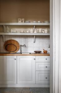 DánszentmiklósHerba-ház的厨房配有白色橱柜和水槽
