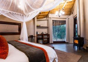 Makalali Game Reserveaha Makalali Private Game Lodge的一间卧室配有一张带天蓬的大床