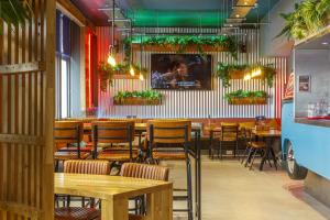 爱丁堡Kick Ass Greyfriars (18+)的餐厅设有木桌和椅子,种有植物
