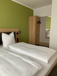 Klein-WinternheimWeingut Bugner Meizelhof的绿色卧室内的一张大白色床