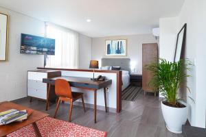 锡劳Arboleda 5的酒店客房设有一张桌子、一张床和一间卧室。
