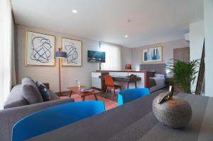 锡劳Arboleda 5的客厅配有沙发和带蓝色椅子的桌子