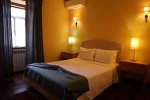 曼泰加什Alojamento Santa Clara的一间卧室配有一张带两盏灯的床和一扇窗户。
