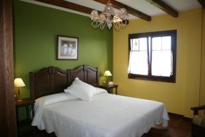 贝梅奥Eco Hotel Rural Lurdeia - Adults Only的一间卧室配有一张白色的床、绿色的墙壁和吊灯。