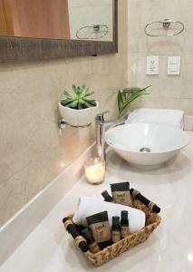 普拉亚卡门Luxury 5th Avenue Menesse 32的浴室设有水槽,并在柜台上提供毛巾篮