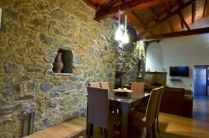 卡洛帕尼亚伊奥蒂斯卡斯特利公寓的一间厨房和带石墙的用餐室