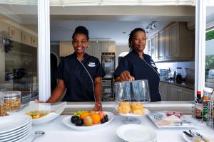 德班森林庄园精品旅馆的两名妇女站在厨房里吃饭
