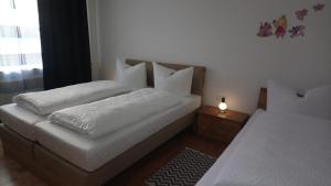 奥伯豪森Altstadt的一间卧室设有两张白色的床和窗户