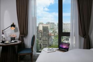 河内The Oriental Jade Hotel的酒店客房,床上配有笔记本电脑,设有窗户
