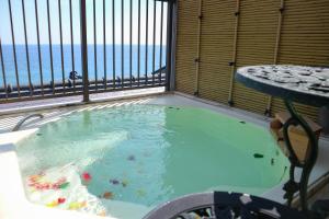 东伊豆町HOTEL&RESORT Izu no Ne的海景阳台上的热水浴池