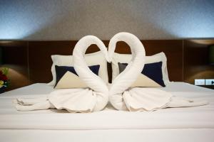 芭东海滩铂金公寓及酒店的两只白天鹅坐在床上
