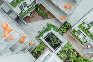 维也纳Oliver Apartments | contactless check-in的庭院的顶部景色,庭院里摆放着橙色椅子和植物