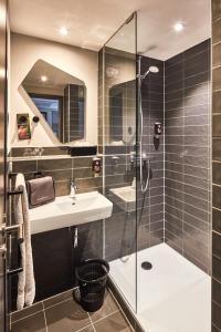 普福尔茨海姆ibis Styles Pforzheim的带淋浴、盥洗盆和镜子的浴室