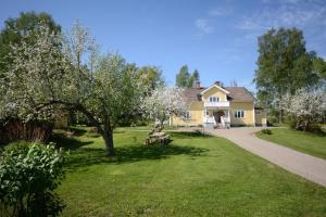 SvanåEden's Garden Cottages的院子里有树的黄色房子