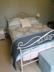 北安普敦Ambles的一间卧室配有一张带蓝色和白色棉被的床