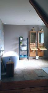 塞尔奈Théière & Couverts - Les Chambres的一间带大型白色浴缸和镜子的浴室