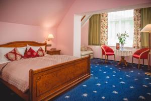 卡尔帕奇利泽登卡酒店的酒店客房带一张床、一张桌子和椅子